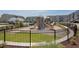Community playground with multiple slides, climbing structures, and safety fencing at 6536 Perry Creek Rd, Raleigh, NC 27616