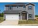 Charming two-story home featuring gray siding, a white garage door, and a well-maintained lawn at 693 White Birch Ln, Angier, NC 27501
