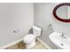 This half bathroom features tiled floors, neutral walls, decorative mirror and elongated pedestal sink at 735 Sycamore Springs Dr, Fuquay Varina, NC 27526