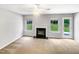 Empty living room featuring a fireplace, neutral carpet, and a view of the green backyard at 735 Sycamore Springs Dr, Fuquay Varina, NC 27526