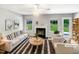 Bright living room with fireplace, neutral colors, and large windows overlooking a green backyard at 735 Sycamore Springs Dr, Fuquay Varina, NC 27526