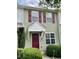 Inviting townhouse with a prominent front door, complemented by red shutters and manicured greenery at 7832 Averette Field Dr, Raleigh, NC 27616