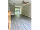Bright living room with updated flooring, sliding glass doors, and a ceiling fan at 7832 Averette Field Dr, Raleigh, NC 27616