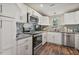 Modern kitchen with white cabinets, stainless steel appliances, and mosaic tile backsplash at 784 Crawford Rd, Coats, NC 27521