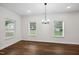 Bright dining room with hardwood floors, modern lighting fixture, and plenty of natural light from surrounding windows at 807 S Mebane St., Burlington, NC 27215