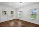 Bright dining room with wood floors, modern chandelier, and multiple windows for ample natural light at 807 S Mebane St., Burlington, NC 27215