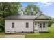 Charming single-story home with light gray siding, black roof, and a welcoming front porch with natural wood columns at 807 S Mebane St., Burlington, NC 27215
