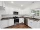 Updated kitchen boasts granite countertops, stainless steel appliances, white cabinets, and wood flooring at 807 S Mebane St., Burlington, NC 27215