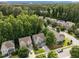 Aerial view of homes in wooded neighborhood, with blue sky and green trees at 904 Pirouette Ct, Raleigh, NC 27606