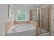 Bright bathroom featuring a jacuzzi tub with a shower in the corner at 904 Pirouette Ct, Raleigh, NC 27606