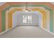 Bright bonus room with large window, ceiling fan, and unique painted color block design at 904 Pirouette Ct, Raleigh, NC 27606