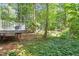 Wooded backyard featuring a deck and lush landscaping at 1 Old Towne Pl, Durham, NC 27713