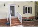 Close up shot of the front porch, brick steps, and garden in front of the yellow home at 1 Old Towne Pl, Durham, NC 27713