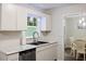 Bright kitchen featuring white cabinets, stainless steel appliances, and a window providing natural light at 1 Old Towne Pl, Durham, NC 27713