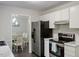 Updated kitchen featuring stainless steel appliances and adjacent view into the dining room at 1 Old Towne Pl, Durham, NC 27713