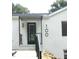 Home's front entrance featuring a modern awning, contemporary address numbers, and stylish black door at 100 Eastwood Lake Rd Rd, Chapel Hill, NC 27514