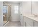 Clean bathroom showcasing a tile shower, double vanity with white cabinets, and a window at 1007 Sora Way, Durham, NC 27703