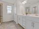 Bright bathroom featuring a double vanity with white cabinets and a tiled floor and large shower at 1007 Sora Way, Durham, NC 27703