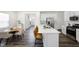 Modern kitchen with an island and seating, connecting to a dining area at 1007 Sora Way, Durham, NC 27703