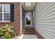 Close up of covered front door with brick accents and surrounding landscaping at 101 Hazel Ln Ln, Broadway, NC 27505