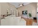 Bright living room with hardwood floors, a large TV, and a comfortable white sectional sofa at 101 Hazel Ln Ln, Broadway, NC 27505