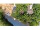 Aerial view of a lakefront property with lush trees, surrounding neighborhood, and a wooden dock at 1033 Sagamore Dr, Louisburg, NC 27549