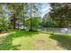Backyard view showing lush green grass, a pier extending onto the lake, and several mature trees at 1033 Sagamore Dr, Louisburg, NC 27549