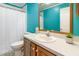 Bright bathroom with turquoise walls, white vanity, and natural light, creating a refreshing space at 1033 Sagamore Dr, Louisburg, NC 27549