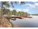 Lakeside view of a dock with boats parked nearby and homes lining the opposite shoreline at 1033 Sagamore Dr, Louisburg, NC 27549