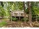 Exterior side view of a home featuring a deck, stairs, landscaping and mature trees at 1033 Sagamore Dr, Louisburg, NC 27549
