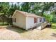 The side exterior of a single story home featuring vinyl siding, red shutters, lakeside access and a wheelchair ramp at 1033 Sagamore Dr, Louisburg, NC 27549