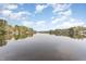 Beautiful lake view showing calm waters, homes along the shoreline, and a clear sky with fluffy clouds at 1033 Sagamore Dr, Louisburg, NC 27549