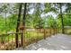 Lakeside view from a wooden back porch featuring hanging baskets and a wood railing at 1033 Sagamore Dr, Louisburg, NC 27549