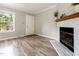 Cozy living area with wood floors, a fireplace, and great natural light from the window at 1033 Sagamore Dr, Louisburg, NC 27549
