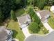 Aerial view of a home featuring a well-manicured lawn, mature trees, and a spacious driveway at 107 Woolard Way, Apex, NC 27502