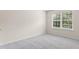 Bright bedroom featuring neutral walls and carpet, and a large window for natural light at 107 Woolard Way, Apex, NC 27502