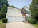 Two-story home with a two-car garage, and brick and cream-colored siding at 107 Woolard Way, Apex, NC 27502
