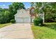 Two-story home with a two-car garage, brick and cream-colored siding, and manicured lawn at 107 Woolard Way, Apex, NC 27502