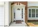 Elegant front door with decorative trim, sidelights, and a transom window, set in brick facade at 107 Woolard Way, Apex, NC 27502