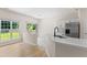 Modern kitchen featuring quartz countertops, a stainless-steel refrigerator, and large windows at 107 Woolard Way, Apex, NC 27502