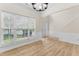 Living room with hardwood floors, decorative wainscoting, and a large window with blinds at 107 Woolard Way, Apex, NC 27502