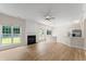 Bright, open-plan living room with hardwood floors, a fireplace, and large windows at 107 Woolard Way, Apex, NC 27502
