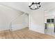 Open room with hardwood floors, staircase, white wainscoting, and views to the kitchen at 107 Woolard Way, Apex, NC 27502