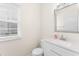 Well-lit powder room with a stylish vanity, a modern mirror, and a window for natural light at 107 Woolard Way, Apex, NC 27502