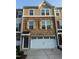 Charming multi-story townhome with brick and shingle siding, complemented by a convenient two-car garage at 1141 Boxcar Way, Apex, NC 27502