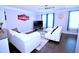 Bright living room featuring modern white sofas, a ceiling fan, and a sleek entertainment center at 1141 Boxcar Way, Apex, NC 27502