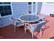 Outdoor patio area with a glass-topped table and four woven chairs at 1141 Boxcar Way, Apex, NC 27502