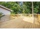 Wooden back deck featuring wood railings and stairs leading to backyard surrounded by trees at 1143 Sturdivant Dr, Cary, NC 27511