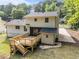Two-story home featuring a wooden deck, grassy backyard, mature trees, and light beige siding at 1143 Sturdivant Dr, Cary, NC 27511