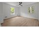 Bright bedroom featuring wood flooring, two windows, a ceiling fan, and neutral walls at 1143 Sturdivant Dr, Cary, NC 27511